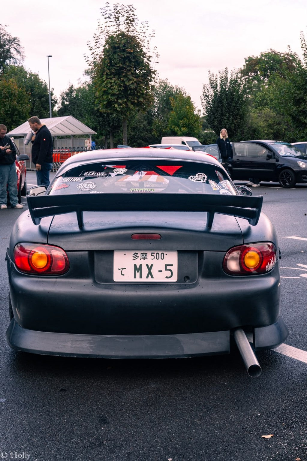 Getunter Mazda MX-5 mit Stickern auf der Heckscheibe bei einem Autotreffen